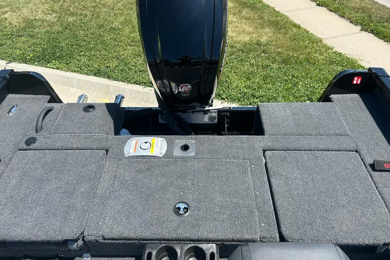 Slide: The Image of 2026 Lund 1775 Impact XS Sport boat deck with motor, featuring carpeted storage compartments. - 15