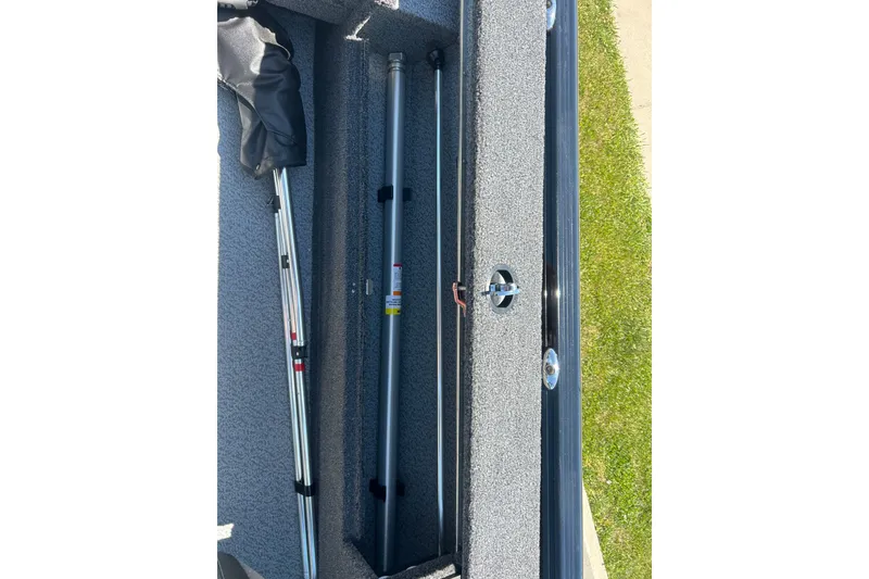 Slide: The Image of Storage compartment of 2026 Lund 1775 Impact XS Sport boat with fishing rods. - 22