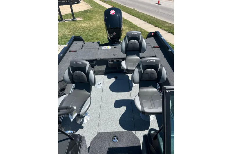 Slide: The Image of 2026 Lund 1775 Impact XS Sport boat interior with four gray seats and motor. - 25