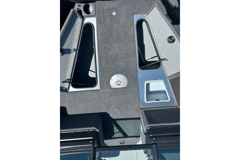 Slide: The Image of 2026 Lund 1775 Impact XS Sport boat interior with storage compartments and carpeted flooring. - 30