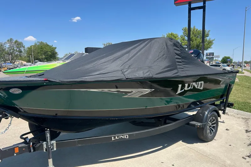 Slide: The Image of 2026 Lund 1775 Impact XS Sport boat with cover on trailer, parked outdoors. - 4