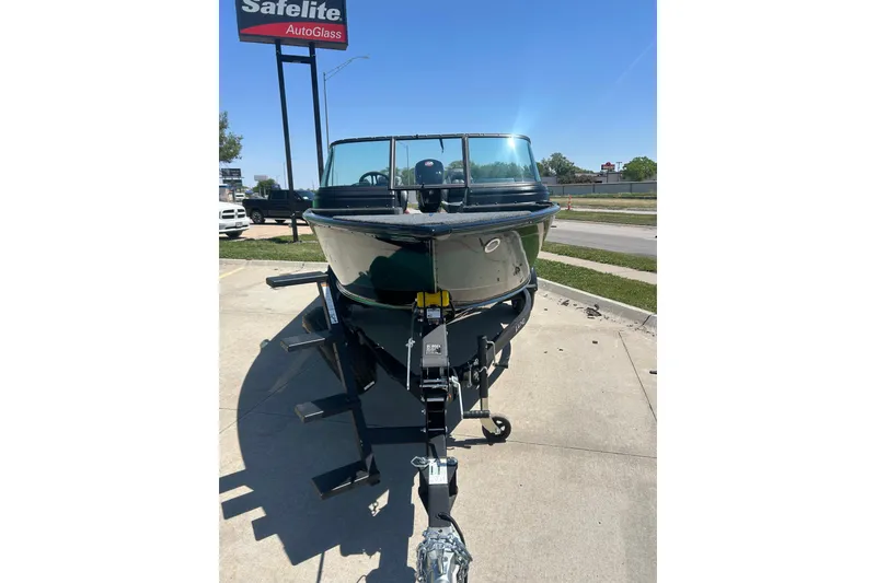 Slide: The Image of 2026 Lund 1775 Impact XS Sport boat on trailer, parked near Safelite AutoGlass sign. - 6