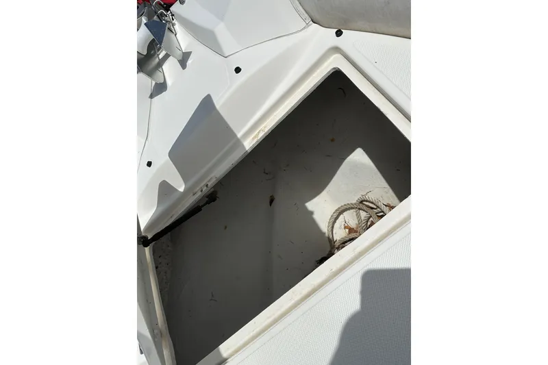Slide: The Image of Open storage compartment on 2023 Zodiac N-ZO 680 boat, containing rope and debris. - 10