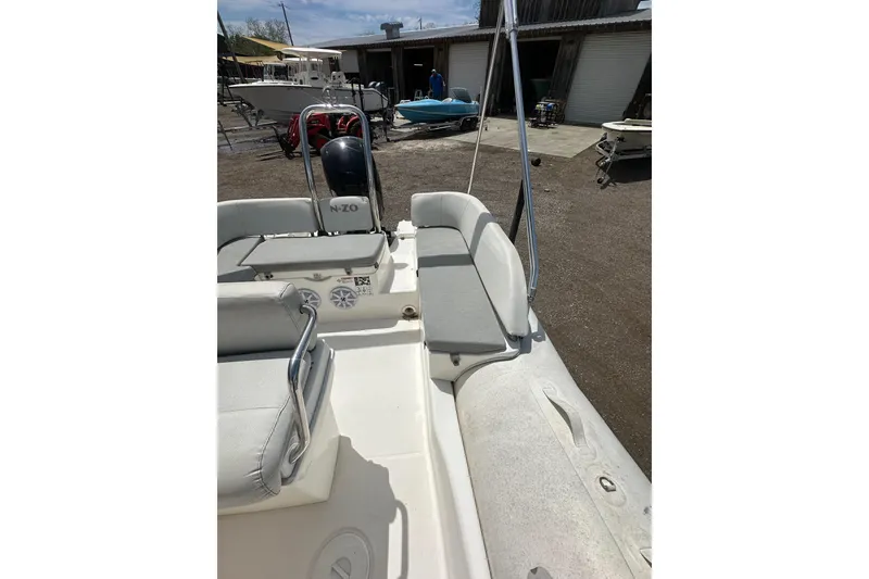 Slide: The Image of 2023 Zodiac N-ZO 680 boat interior with seating and motor, parked outdoors. - 14