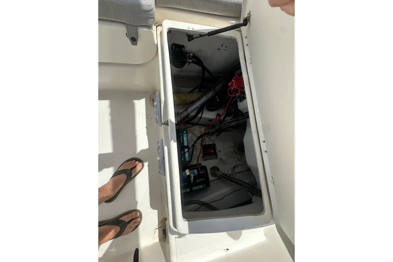 Slide: The Image of Open storage compartment of 2023 Zodiac N-ZO 680 boat showing internal wiring and components. - 17