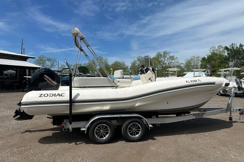 Slide: The Image of 2023 Zodiac N-ZO 680 boat on trailer, parked outdoors under clear sky. - 5