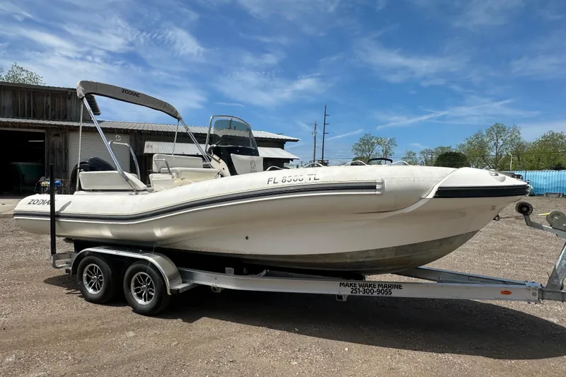Slide: The Image of 2023 Zodiac N-ZO 680 boat on trailer, parked outdoors under clear blue sky. - 6
