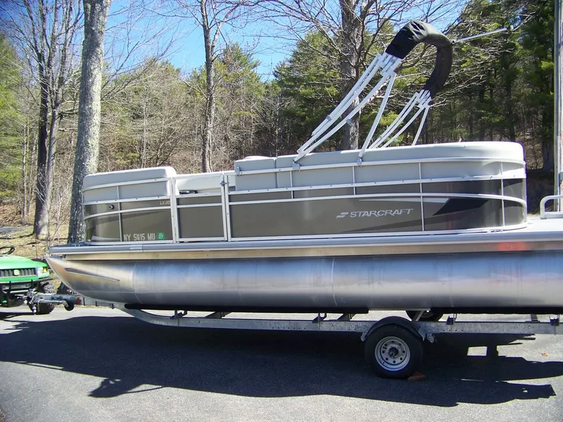 Slide: The Image of 2024 Starcraft LX 20 R pontoon boat on trailer outdoors. - 7