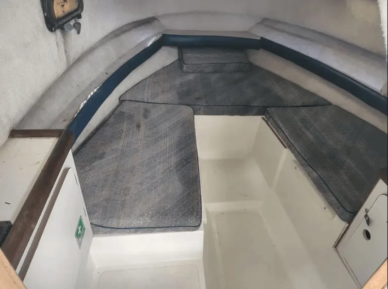 Slide: The Image of Interior of a 1990 Pursuit 2350 boat with gray cushions. - 11