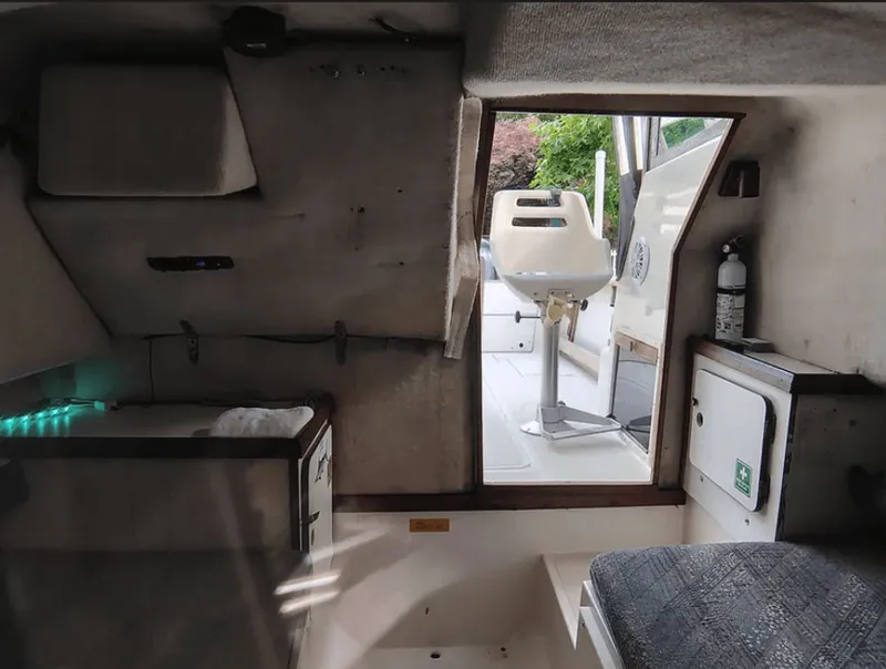 Slide: The Image of Interior of a 1990 Pursuit 2350 boat with seating and fire extinguisher. - 12