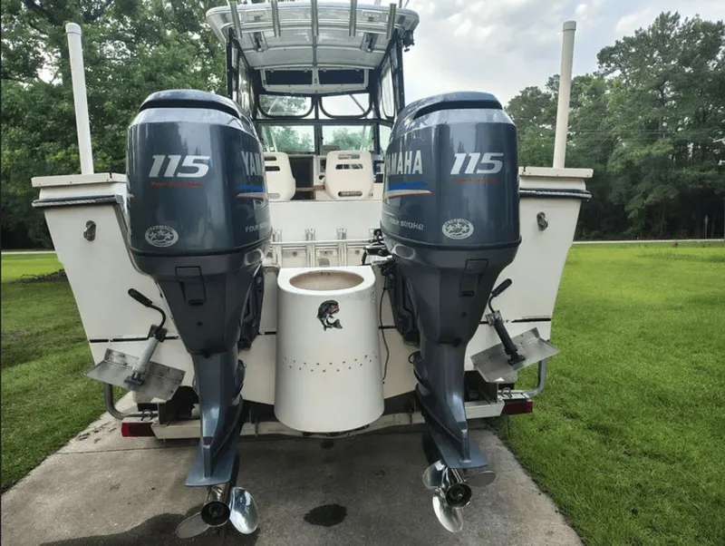 Slide: The Image of 1990 Pursuit 2350 boat with Yamaha 115 engines in a green setting. - 15