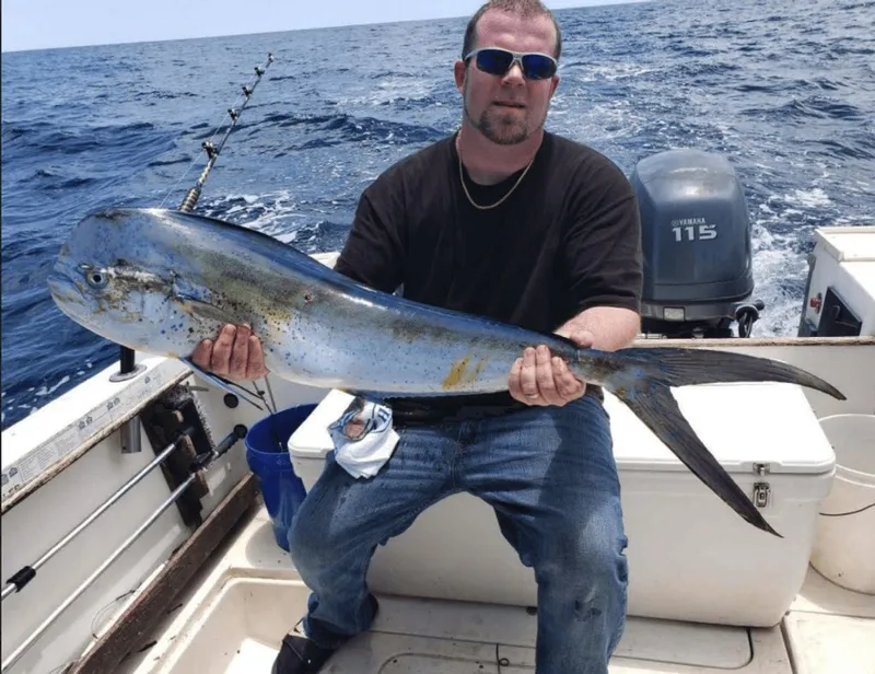 Slide: The Image of Angler holding large fish on 1990 Pursuit 2350 boat. - 16