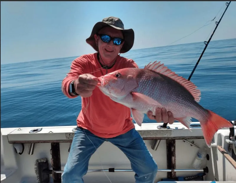 Slide: The Image of Angler holding fish on a 1990 Pursuit 2350 boat. - 18