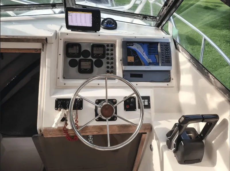 Slide: The Image of 1990 Pursuit 2350 boat helm with navigation system and controls. - 6