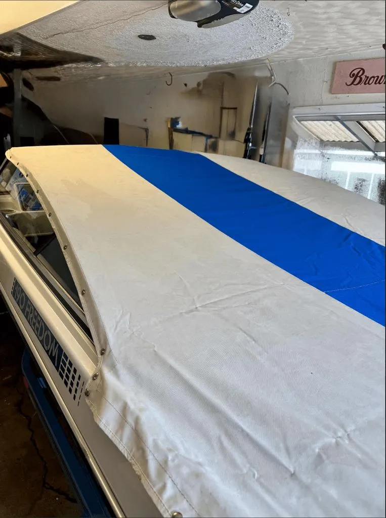 The Image of 1989 Four Winns 190 Freedom boat with blue cover in garage. - 8