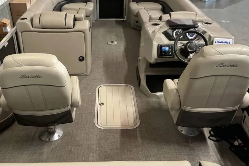 Slide: The Image of Interior of a 2021 Barletta E24UC pontoon boat with plush seating and modern dashboard. - 11