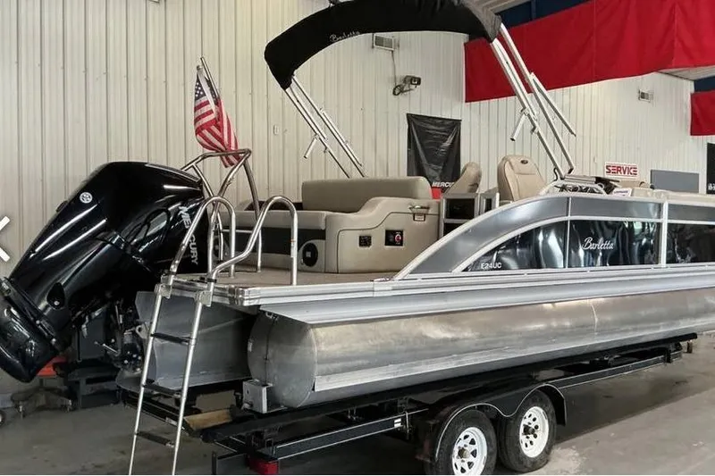 Slide: The Image of 2021 Barletta E24UC pontoon boat with Mercury engine on trailer in indoor facility. - 3