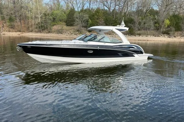 Slide: The Image of 2025 Formula 350 Crossover Bowrider I/O cruising on a calm lake near a wooded shoreline. - 31