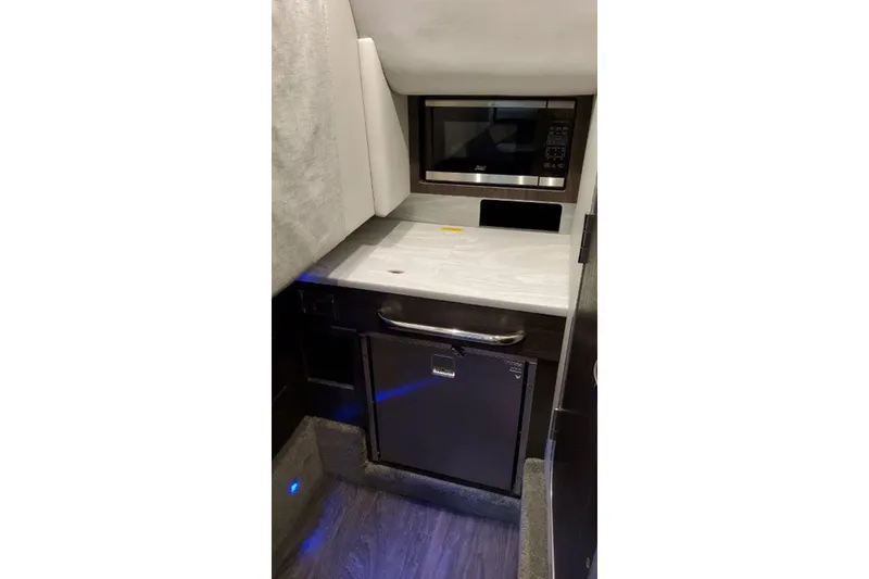 Slide: The Image of Interior of 2025 Formula 350 Crossover Bowrider I/O featuring a compact kitchenette. - 9