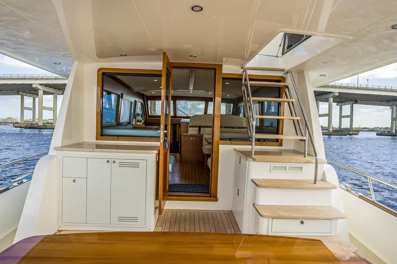 Slide: The Image of 2023 Grand Banks GB54 yacht interior with wooden stairs and seating area. - 10