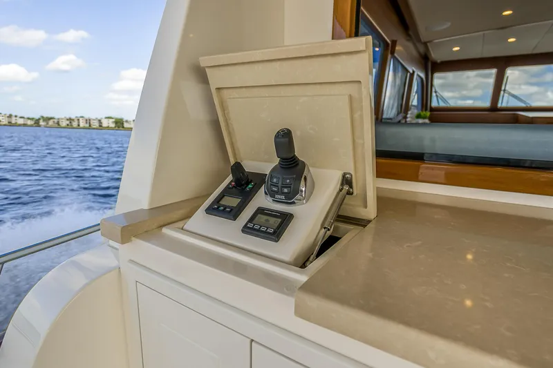 Slide: The Image of Control panel on 2023 Grand Banks GB54 yacht, featuring joystick and digital displays. - 13