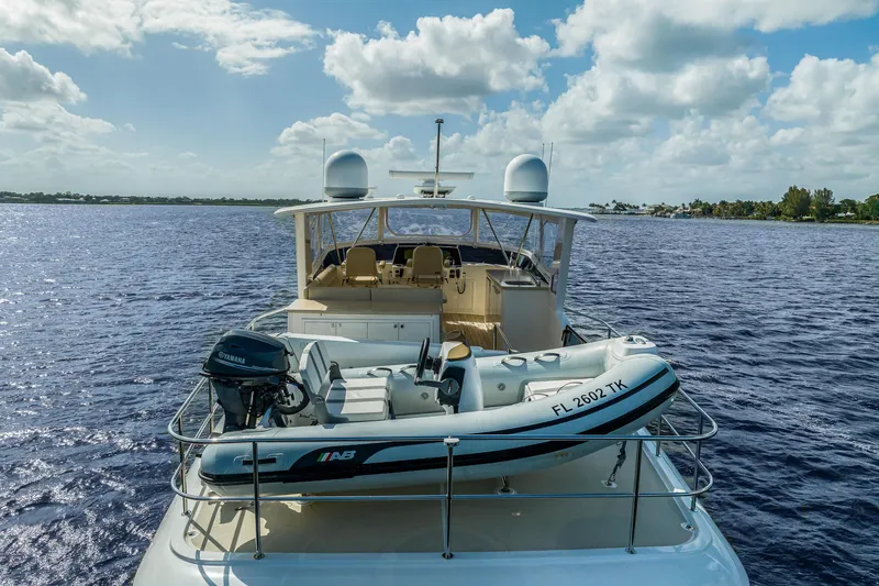 Slide: The Image of 2023 Grand Banks GB54 yacht with tender on deck, cruising on a sunny day. - 19