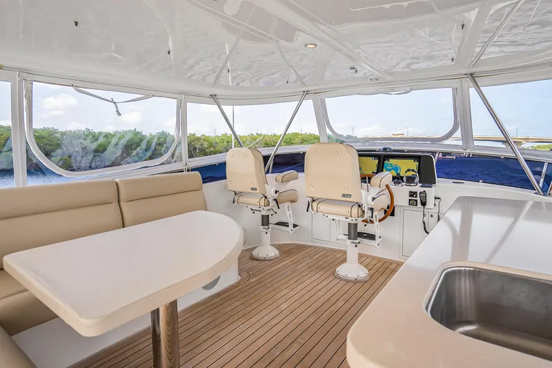 Slide: The Image of Luxurious 2023 Grand Banks GB54 yacht interior with helm, seating, and panoramic windows. - 2