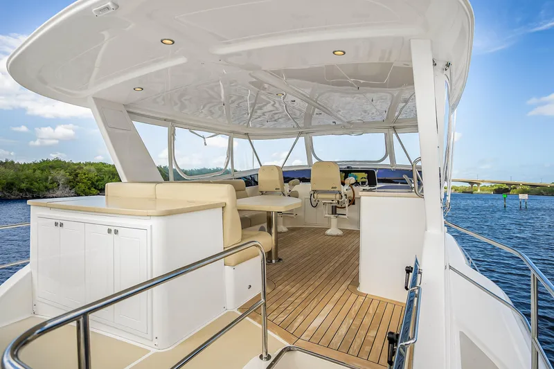 Slide: The Image of Luxurious 2023 Grand Banks GB54 yacht interior with seating and helm, overlooking serene waters. - 24