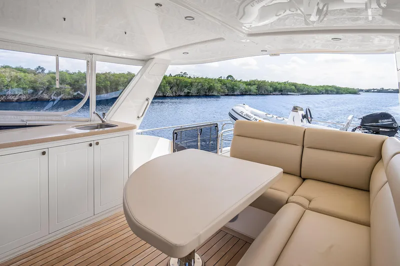 Slide: The Image of Luxurious 2023 Grand Banks GB54 yacht interior with seating, table, and scenic water view. - 31