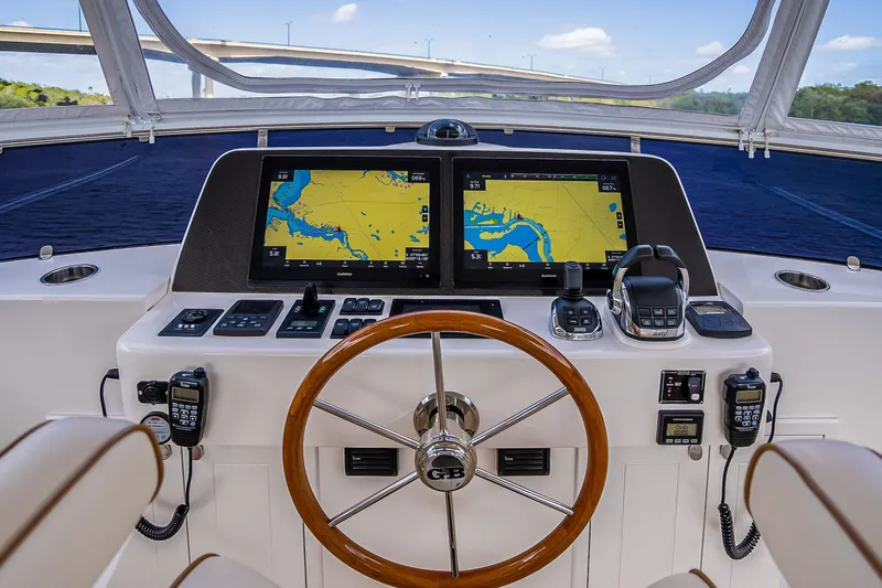 Slide: The Image of 2023 Grand Banks GB54 helm with dual navigation screens and wooden steering wheel. - 37