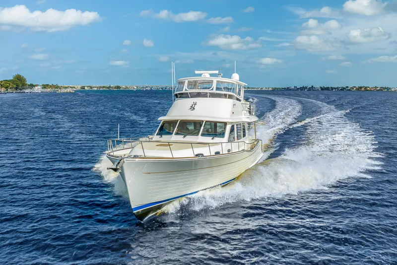 Slide: The Image of 2023 Grand Banks GB54 yacht cruising on open water under a clear blue sky. - 5