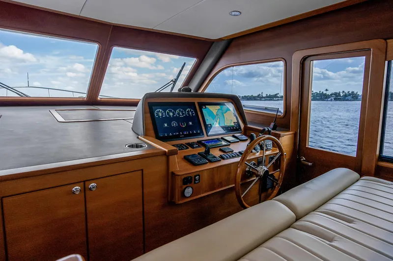 Slide: The Image of 2023 Grand Banks GB54 yacht helm with navigation screens and wooden steering wheel. - 50