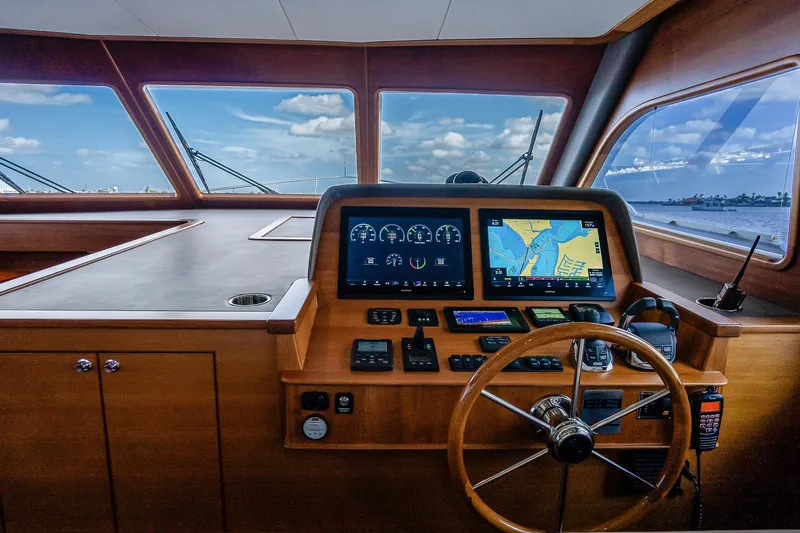 Slide: The Image of 2023 Grand Banks GB54 yacht helm with navigation screens and wooden steering wheel. - 51