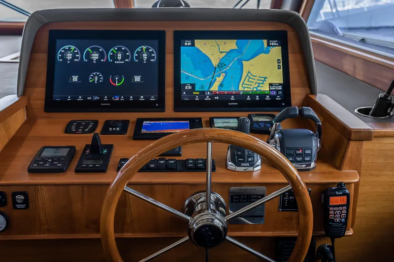 Slide: The Image of 2023 Grand Banks GB54 helm with advanced navigation and control systems, featuring dual displays. - 52