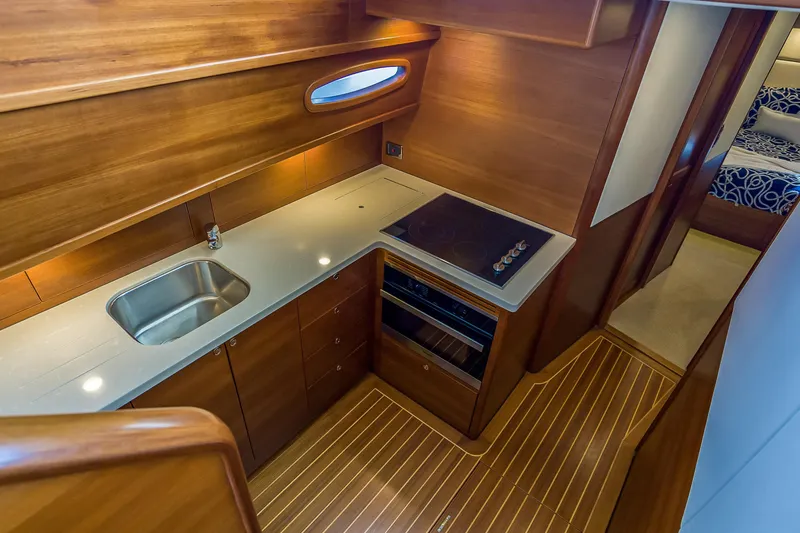 Slide: The Image of Luxurious 2023 Grand Banks GB54 yacht kitchen with modern appliances and elegant wood finish. - 55