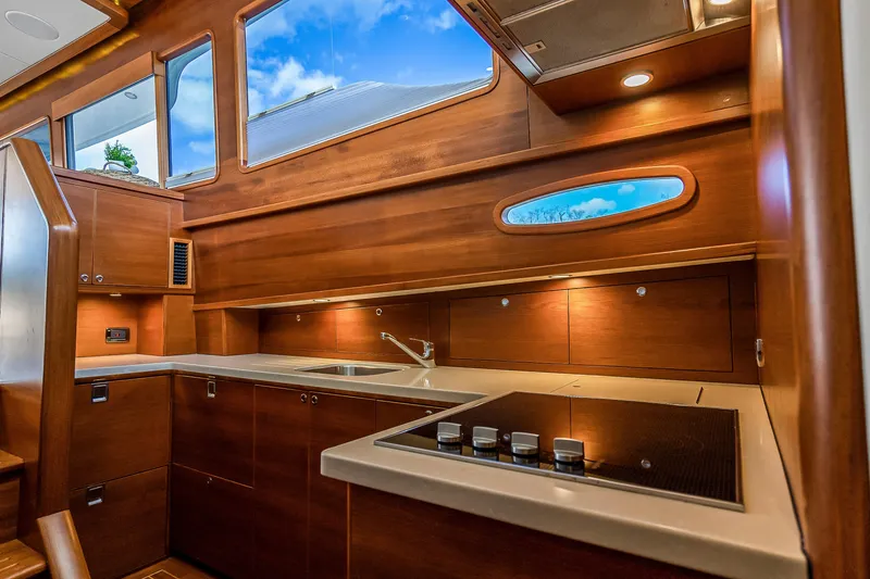 Slide: The Image of Luxurious 2023 Grand Banks GB54 yacht kitchen with modern wood cabinetry and sleek appliances. - 56