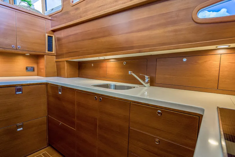Slide: The Image of 2023 Grand Banks GB54 yacht kitchen with wooden cabinetry and modern sink. - 57