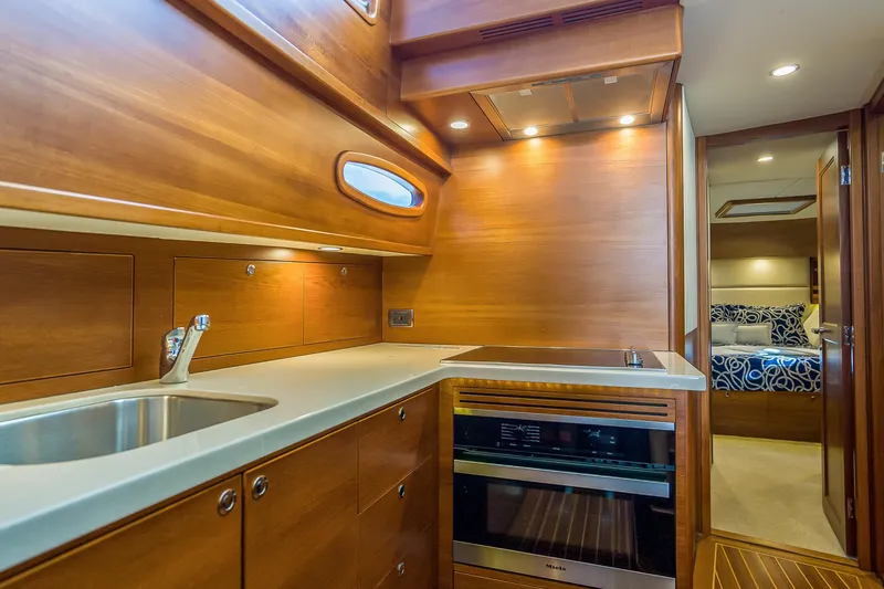 Slide: The Image of Luxurious 2023 Grand Banks GB54 yacht kitchen with modern appliances and elegant wood finish. - 59