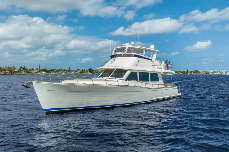 Slide: The Image of 2023 Grand Banks GB54 yacht cruising on open water under a partly cloudy sky. - 6