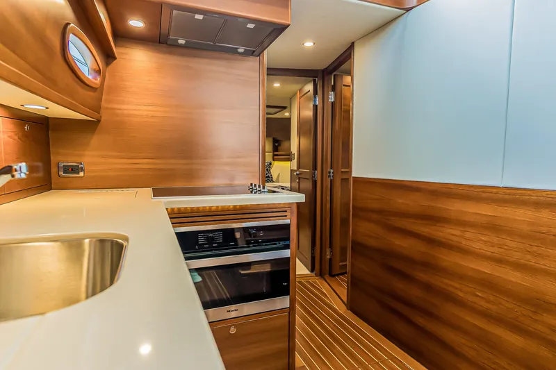 Slide: The Image of Luxurious 2023 Grand Banks GB54 yacht interior with modern kitchen design and wood finishes. - 62