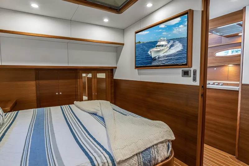 Slide: The Image of Luxurious 2023 Grand Banks GB54 yacht cabin with elegant wood finishes and nautical decor. - 67