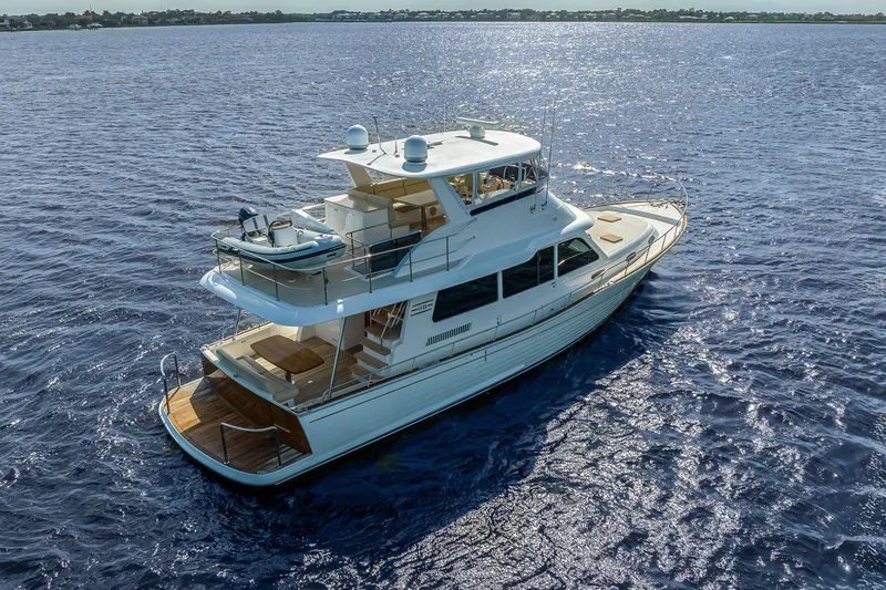 Slide: The Image of 2023 Grand Banks GB54 yacht cruising on open water, showcasing luxury design and spacious deck. - 7