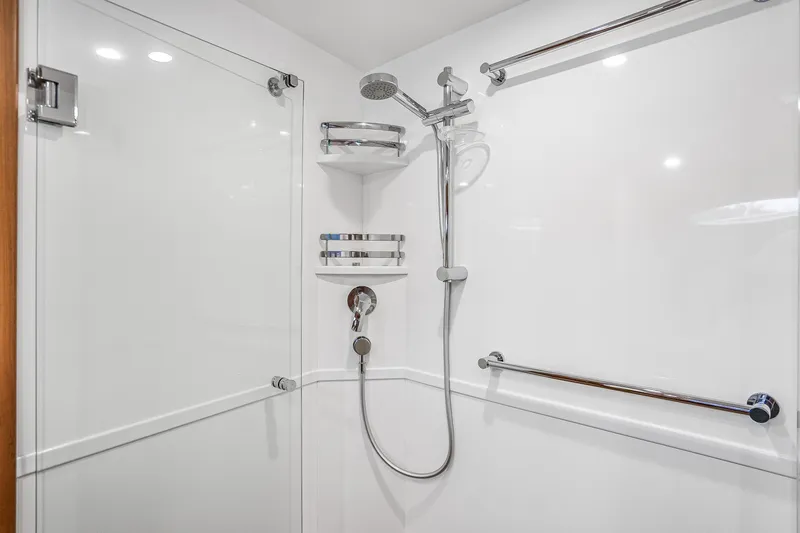 Slide: The Image of Modern shower in 2023 Grand Banks GB54 yacht, featuring sleek chrome fixtures and white walls. - 73