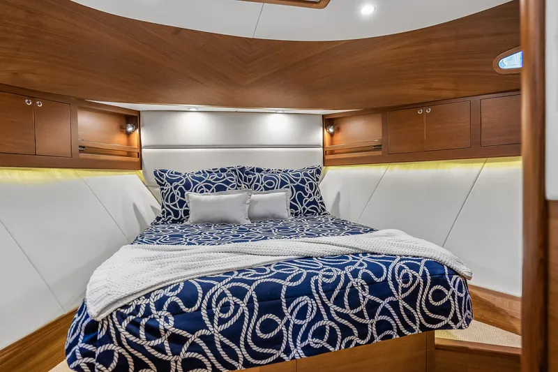 Slide: The Image of Luxurious 2023 Grand Banks GB54 yacht cabin with elegant bedding and wooden cabinetry. - 74