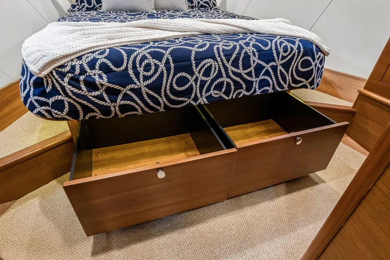 Slide: The Image of 2023 Grand Banks GB54 yacht bedroom with under-bed storage drawers open. - 76