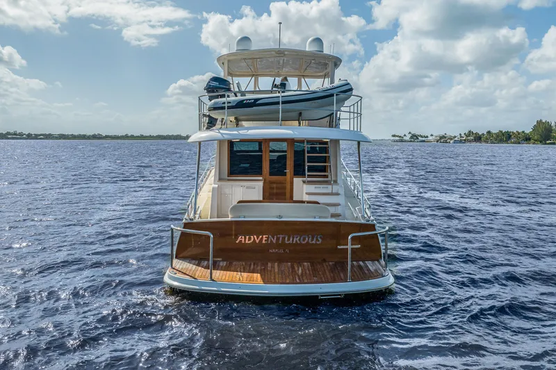 Slide: The Image of 2023 Grand Banks GB54 yacht on open water, rear view with dinghy on deck. - 8