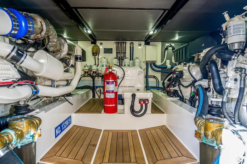 Slide: The Image of Engine room of 2023 Grand Banks GB54 yacht, featuring modern equipment and fire extinguisher. - 81