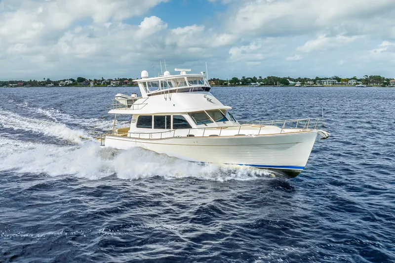 Slide: The Image of 2023 Grand Banks GB54 yacht cruising on open water under a cloudy sky. - 85