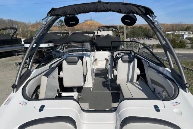 Slide: The Image of 2019 Yamaha Boats AR240 interior with seating and steering wheel, docked outdoors. - 6