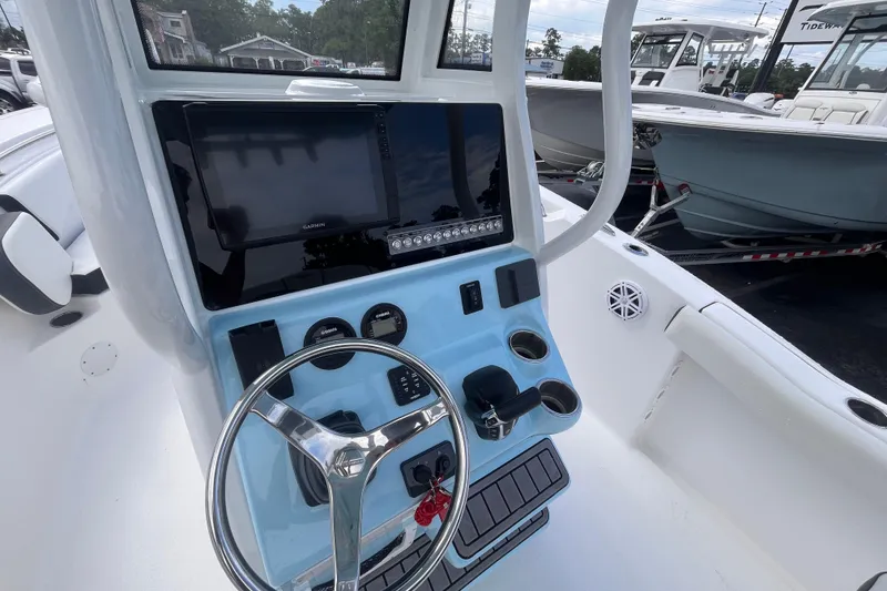 Slide: The Image of 2023 Tidewater 232 CC Adventure boat dashboard with steering wheel and navigation display. - 12